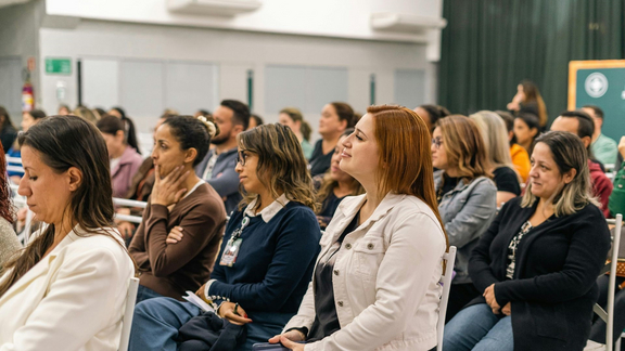 Menschen auf einer Veranstaltung in Stuhlreihen mit Blick von der Seite