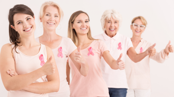 Frauen verschiedenen Alters in rosa TShirts mit dem Zeichen gegen Brustkrebs
