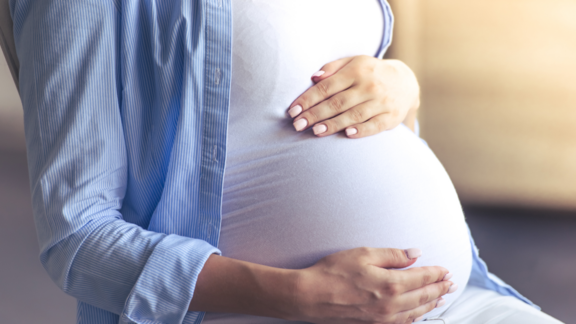 Frau die sich über den schwangeren Bauch streichelt